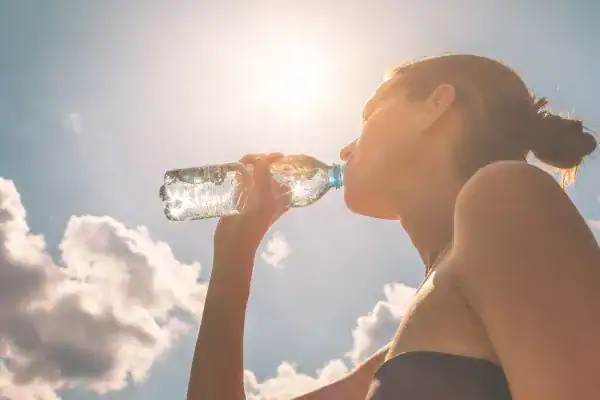 Hydration: The Secret Ingredient for a Toned Stomach and Enhanced Fitness 3 Image of woman drinking water to hydrate Hamilton after run.