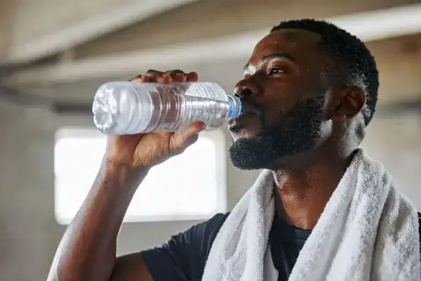 Hydration: The Secret Ingredient for a Toned Stomach and Enhanced Fitness 1 Image of man drinking water to improve hydration Hamilton after work out.